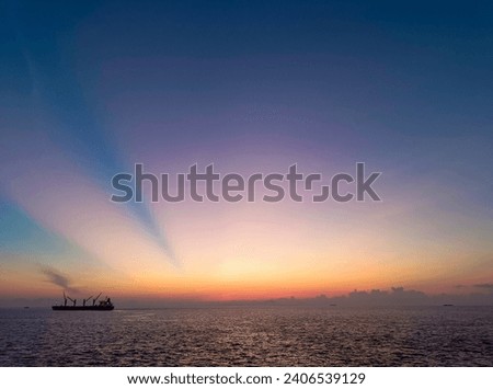 Sunrise at the middle of sea, with silhouette of the ship