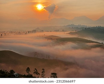 Sunrise in a mountainous area with mist reflecting the sun. Sunrise at Cukul Plantation, Pangalengan, Bandung, Indonesia - Shutterstock ID 2312066697