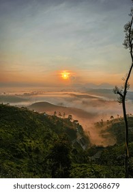 Sunrise in a mountainous area with mist reflecting the sun. Sunrise at Cukul Plantation, Pangalengan, Bandung, Indonesia - Shutterstock ID 2312068679