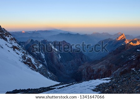 Sunrise in mountains. Reflection of red sun on mountain snow peaks, Fann, Pamir Alay, Tajikistan