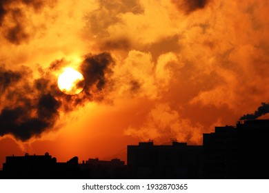 Sunrise on colorful dramatic sky, orange sun shining through dark clouds above the buildings silhouettes. Picturesque city landscape for horror background - Powered by Shutterstock