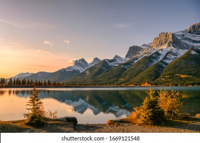 Sunrise on Mount Rundle with blue sky reflection on Rundle Forebay reservoir in autumn at Canmore, Canada