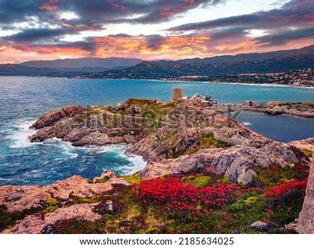 Sunrise on Pietra cape with Genoise de la Pietra a L'ile-Rousse tower on background. Dramatic morning scene of Corsica island, France, Europe. Traveling concept background.