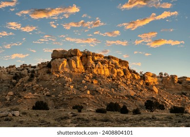 Sunrise on a Rocky Mesa in the New Mexico landscape with small puffy clouds in the blue sky. - Powered by Shutterstock