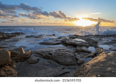 Sunrise on the rocky seashore in Malta on the shore of the rough sea - Powered by Shutterstock