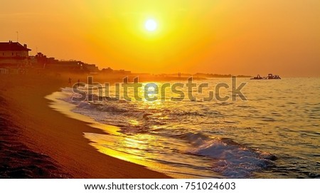 Sunrise over the coast of Costa del Maresme. Rocks, beach, sea and sand at sunrise.