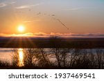 sunrise over columbia river with geese flying near hanford reach