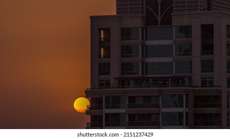 Sunrise Over Dubai Marina Luxury Tourist District With Sun Rising Behind Skyscraper Aerial Timelapse. Recidential Buildings And Orange Sky