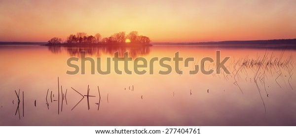 Sunrise\
over foggy lake in early spring. Letterbox\
format