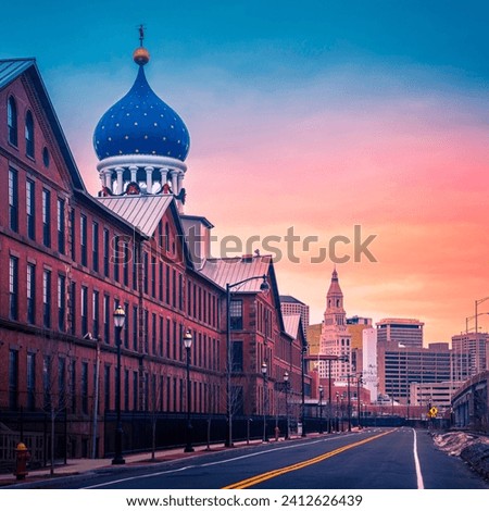 Sunrise over Hartford City Skyline and historic landmark buildings along the I-91 Interstate Highway, a view from Charter Oak Landing of Connecticut River, USA, a snow-covered winter landscape