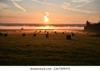 Sunrise over the lake with haybales. Mist rising over the lake with sunrise.  - Powered by Shutterstock