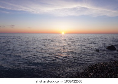 Sunrise over a lake from a rocky beach
