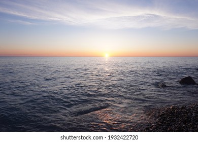 Sunrise over a lake from a rocky beach
