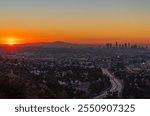 Sunrise over Los Angeles, USA, skyline of downtown, hollywood and view of the traffic on the freeway, with trail lights from cars.