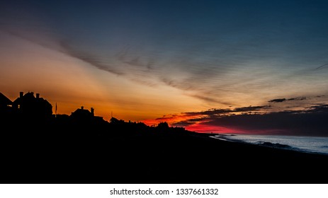 Sunrise Over Mansions And Beach Of Southampton, NY In The Summer. Sky On Fire With Harsh Outline Of Beachside Mansions. 