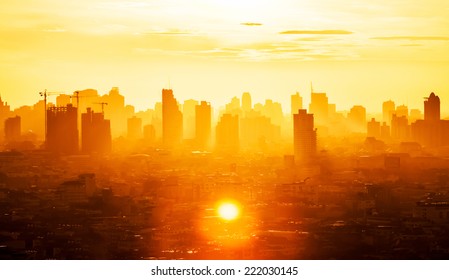 Sunrise over modern office buildings in business district center of Bangkok. Skyline view of cityscape with sunlight and flare in warm light color tone. Construction business concept.
