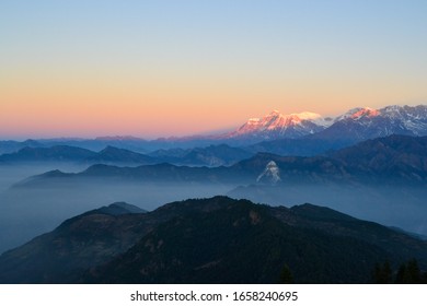Sunrise over mountain range with clouds in valley