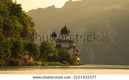 Sunrise over Mraconia Monastery church from Romania at the shore of Danube river. Landmark landscape from Danube Gorges.