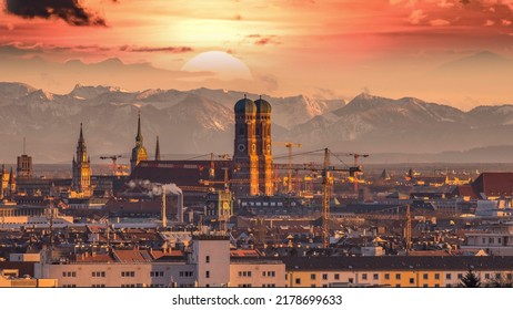 Sunrise over Munich Germany city, munich skyline aerial view in background pre alps mountains colored sky frauenkirche church cathedral marienplatz.