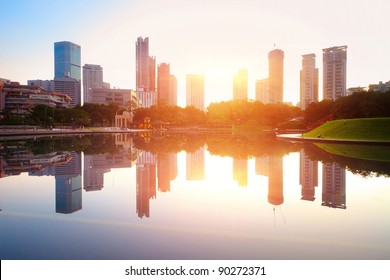Sunrise over pond in a city. Kuala Lumpur skyline
