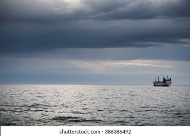 Sunrise over the sea and sailing cargo ship
