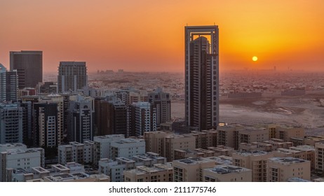 Sunrise over skyscrapers in Barsha Heights district and low rise buildings in Greens district aerial timelapse. Dubai skyline with orange sky at morning with desert on a background - Powered by Shutterstock