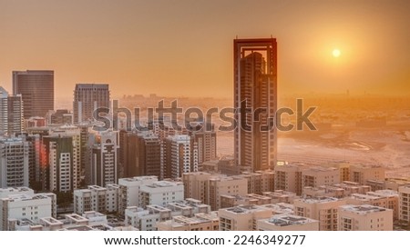 Sunrise over skyscrapers in Barsha Heights district and low rise buildings in Greens district aerial . Dubai skyline with orange sky at morning with desert on a background