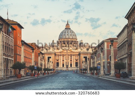 Sunrise over the St. Peters Basilica in Vatican City. Morning at the most famous landmark, empty of people street, cloudy sky.