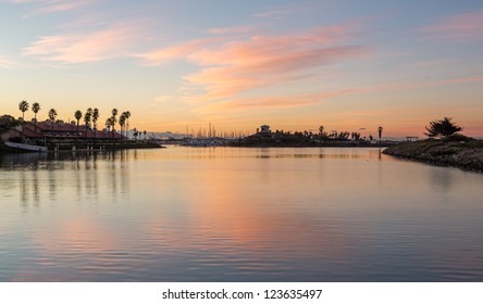 Sunrise over timeshare development by water in Ventura California with modern homes and yachts boats