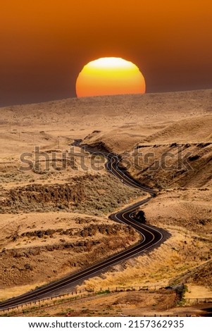 Sunrise over a winding and curvey road in eastern Washington high desert country