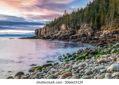 The Sunrise Paints The Sky With Color And Shines Warmly On The Otter Cliffs Rising Out Of The Sea At Boulder Beach In Acadia National Park, Mt. Desert Island, Maine.