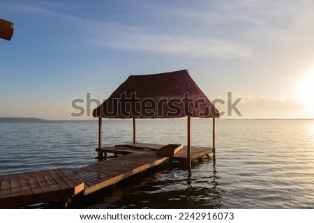 Sunrise from the palapa and pier at the hotel at the foot of the lagoon in Bacalar.