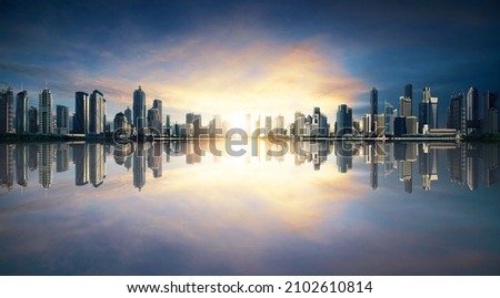 sunrise panorama of waterfront city skyline with reflection. Image composite.