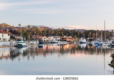 Sunrise at residential development by water in Ventura California with modern homes and yachts boats