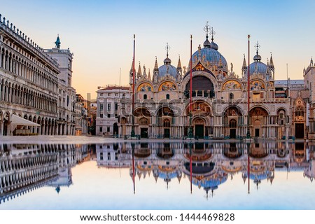 Sunrise in San Marco square with Campanile and San Marco's Basilica. The main square of the old town. Venice, Veneto Italy. Reflection on the flooded square.