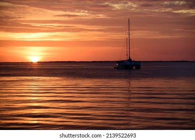 Sunrise in the sea with soft wave and cloudy. Sunset with large yellow sun under the sea surface. Calm ocean with sunset sky and sun through the clouds over. Calm ocean and sky background.
