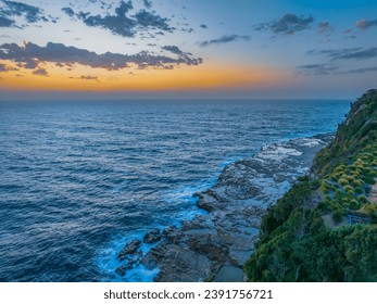 Sunrise seascape with clouds and rocks at Avoca Beach on the Central Coast, NSW, Australia.