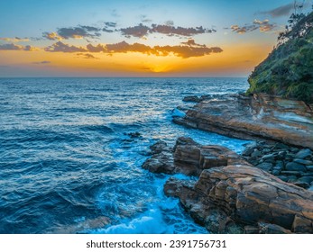 Sunrise seascape with clouds and rocks at Avoca Beach on the Central Coast, NSW, Australia.