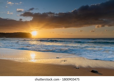 Sunrise seascape with medium cloud coverage at MacMasters Beach on the Central Coast, NSW, Australia.