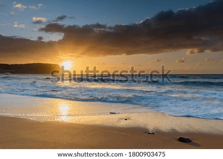 Sunrise seascape with medium cloud coverage at MacMasters Beach on the Central Coast, NSW, Australia.