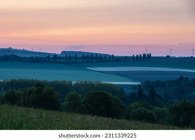 Sunrise in spring time with the silhouette of the typical Tuscan Poplar trees in a line alongside a road during the golden hour and the sun on the horizon. - Shutterstock ID 2311339225