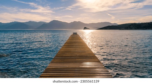 Sunrise at the Steeg into the water in front of a mountain panorama, Agrigates Desert, Corsica - Powered by Shutterstock