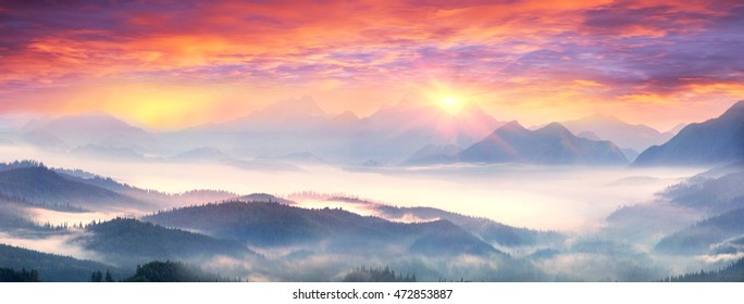  sunrise, the sun's rays illuminate the beautiful panorama of the Carpathian village against backdrop of scenic mountains, where the highlanders live Hutsul. Wild forests, fields pastures - Shutterstock ID 472853887