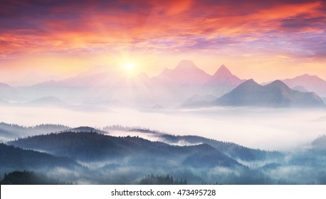  sunrise, the sun's rays illuminate the beautiful panorama of the Carpathian village against backdrop of scenic mountains, where the highlanders live Hutsul. Wild forests, fields pastures - Powered by Shutterstock