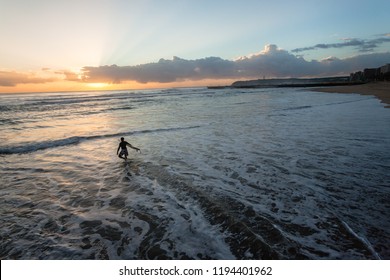 Sunrise Surfer Silhouetted Going Surfing Enters Ocean Waters Along Durban Beachfront South-Africa.