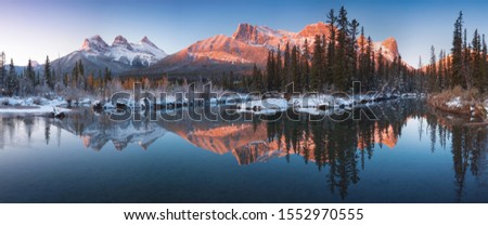 Sunrise of the Three Sisters and the Bow River from Canmore near Banff National Park.
First snow in Canadian Rockies. Beautiful landscape background concept. Christmas time