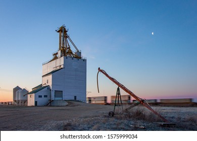 Sunrise Train Passing A Grain Elevator