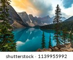Sunrise with turquoise waters of the Moraine lake with sin lit rocky mountains in Banff National Park of Canada in Valley of the ten peaks.