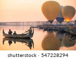 Sunrise at U Bein Bridge with boat and hot air balloon, Mandalay, Myanmar.