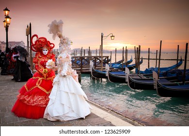 Sunrise in Venice Italy in front of Gondolas on the Grand Canal Beautiful costumed women